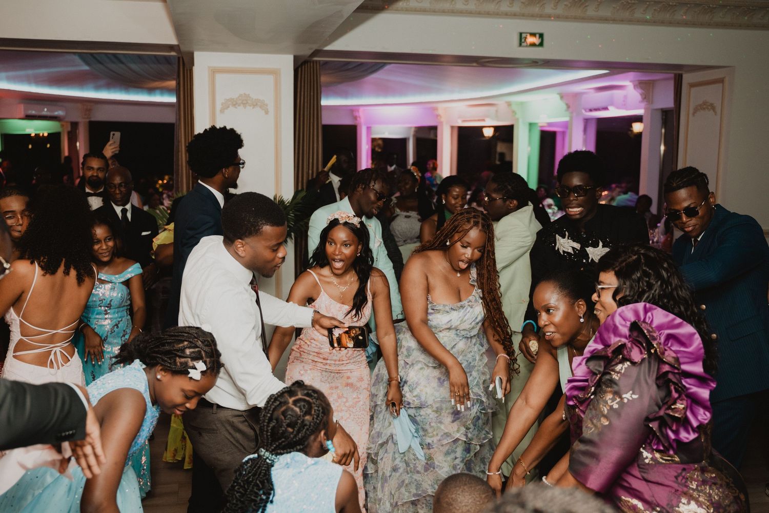 La piste de danse de la réception de mariage était remplie d'invités qui célébraient sous un éclairage d'ambiance.