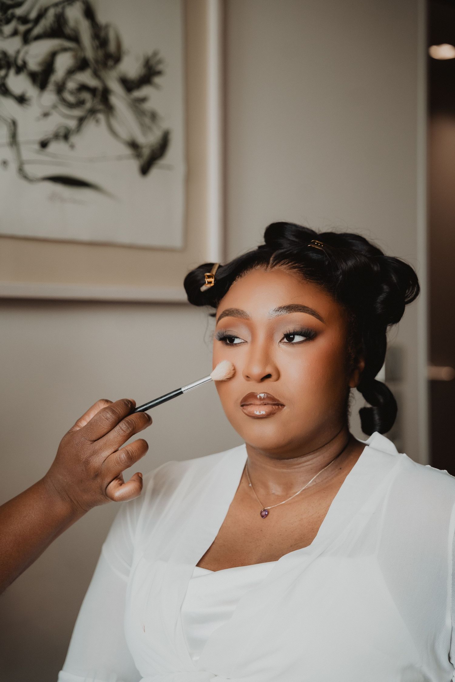 Une maquilleuse applique du maquillage lors des préparatifs de mariage.