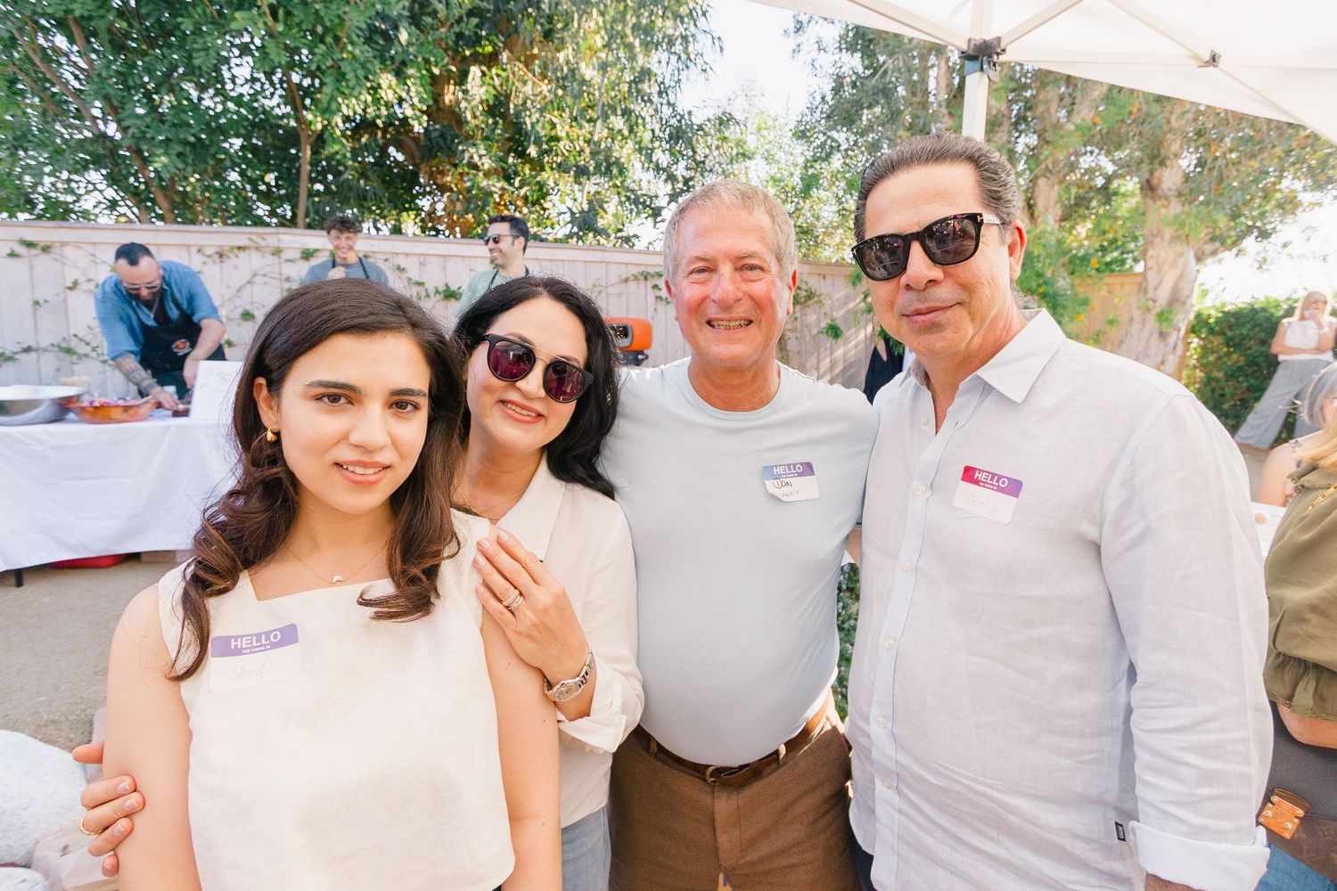 Group photo of party guests at a sunny outdoor gathering.