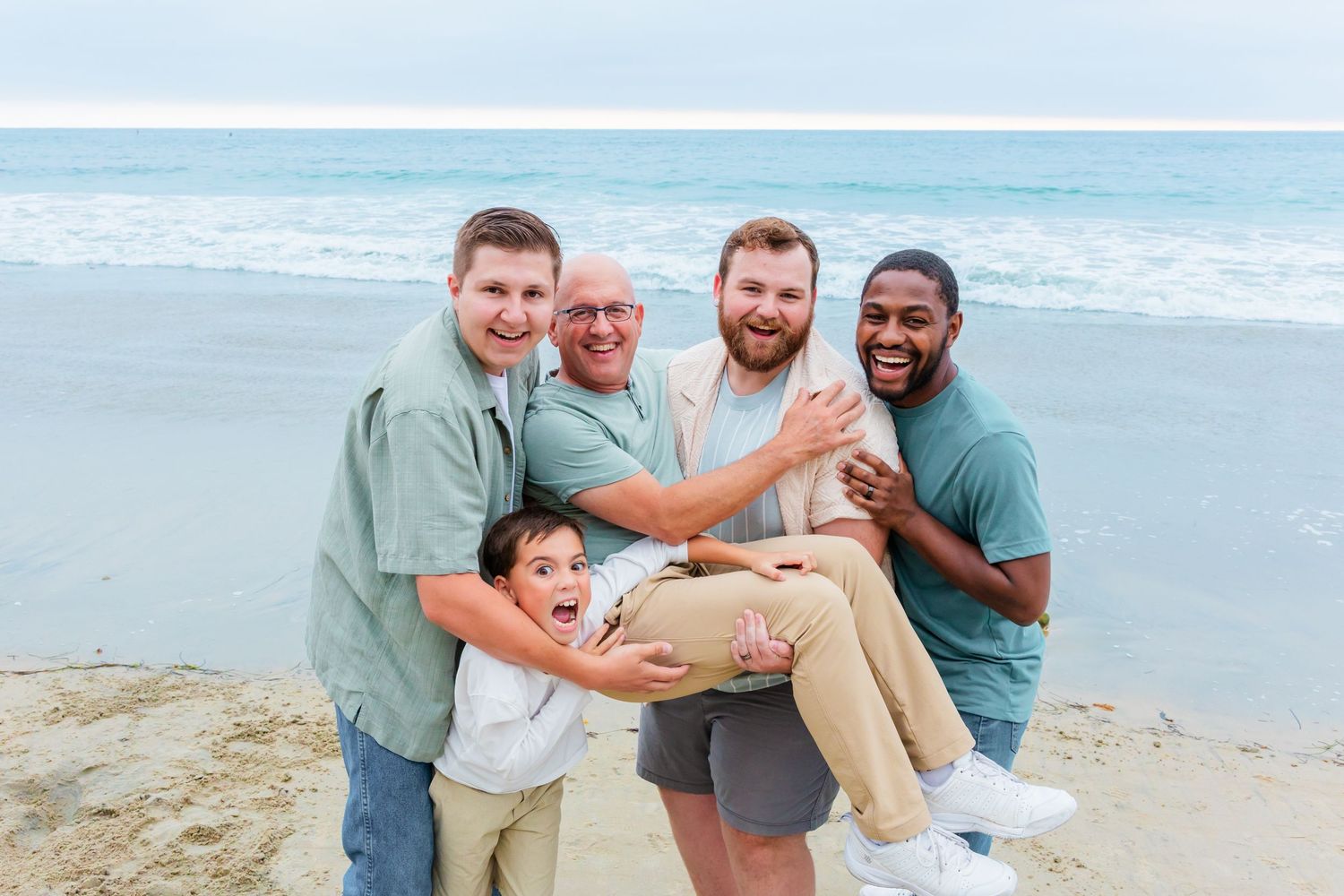 A group of people share a playful moment together on the beach.