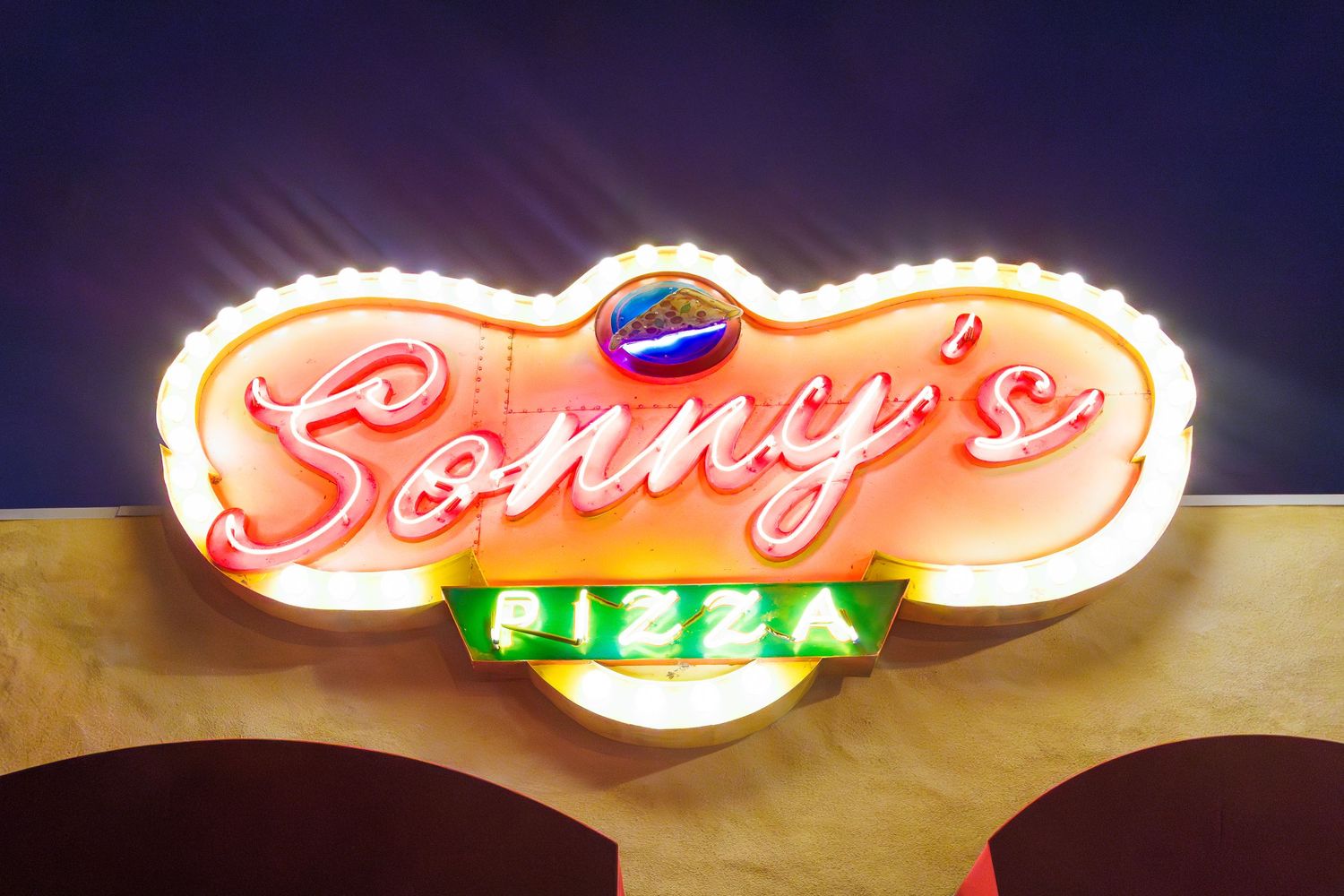 Illuminated vintage-style neon sign for a restaurant or bar glowing in the night.