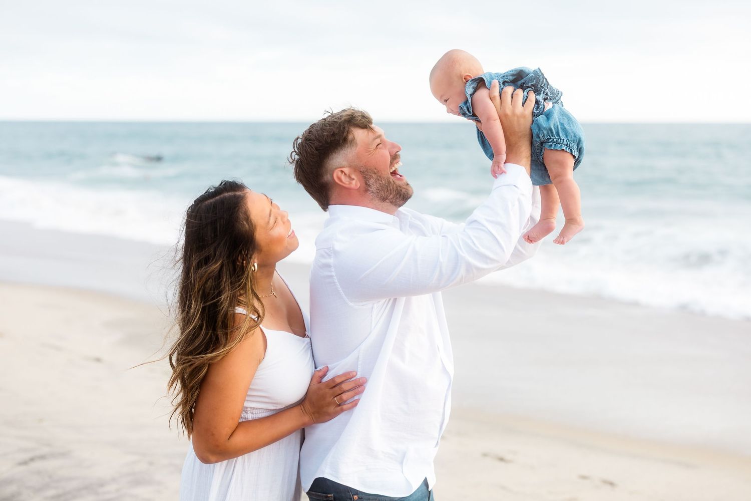 Candid family photographs taken on a pristine beach with rolling waves.