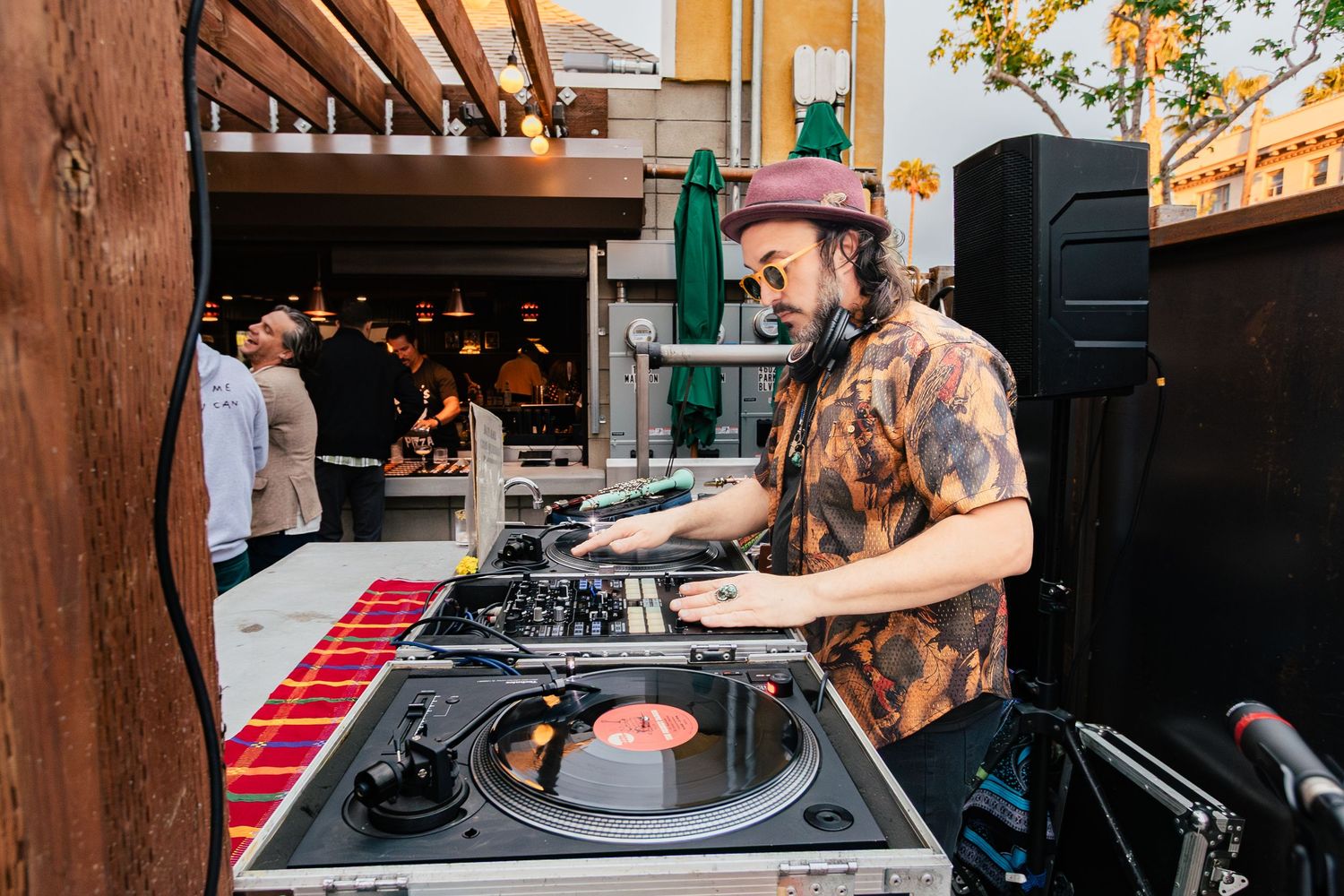 DJ equipment setup at an outdoor venue with turntables and mixing gear.
