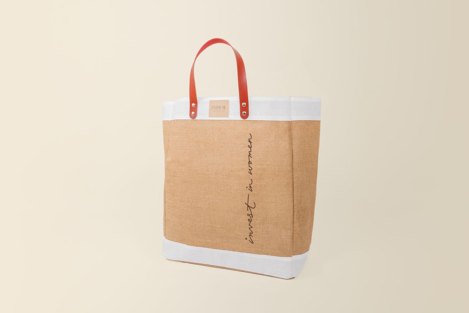 Stylish canvas tote bag with vertical text detail and contrasting red handles.