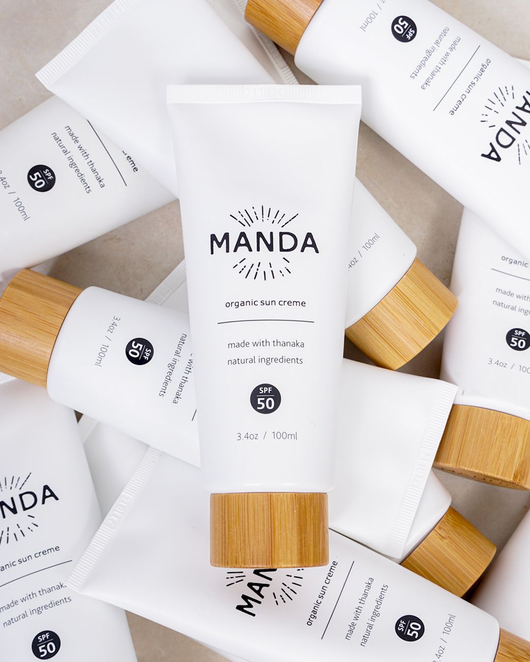 Overhead view of white business cards with wooden accents and Manda branding arranged on a light surface.