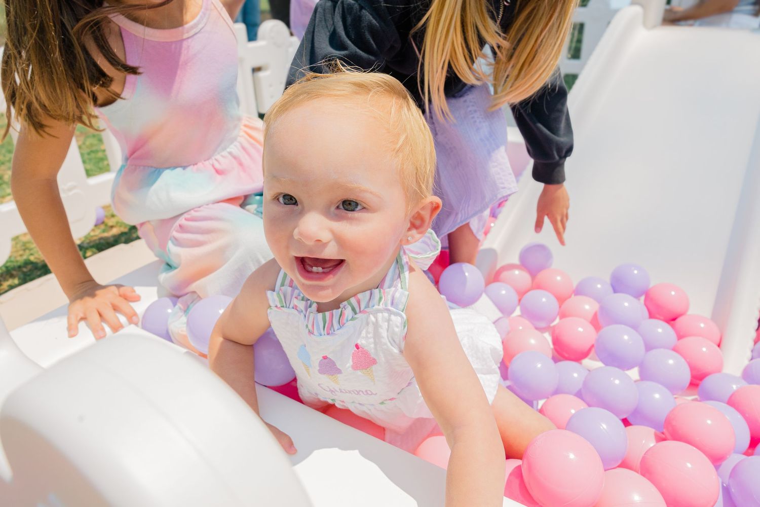 Pink and purple ball pit area set up at an outdoor children's party.