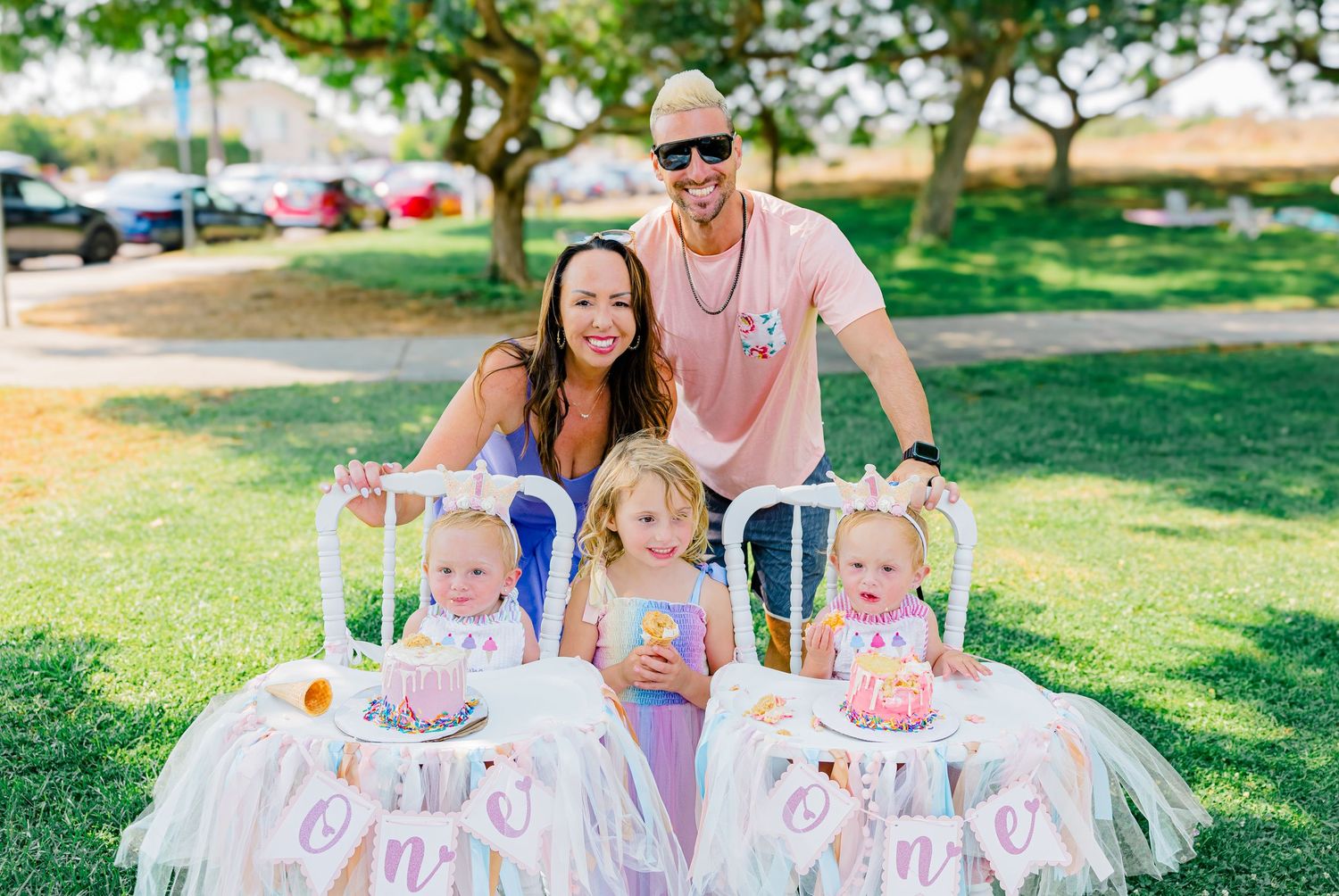 Summer party scene with white picket fence and pink decorations in a grassy outdoor area.