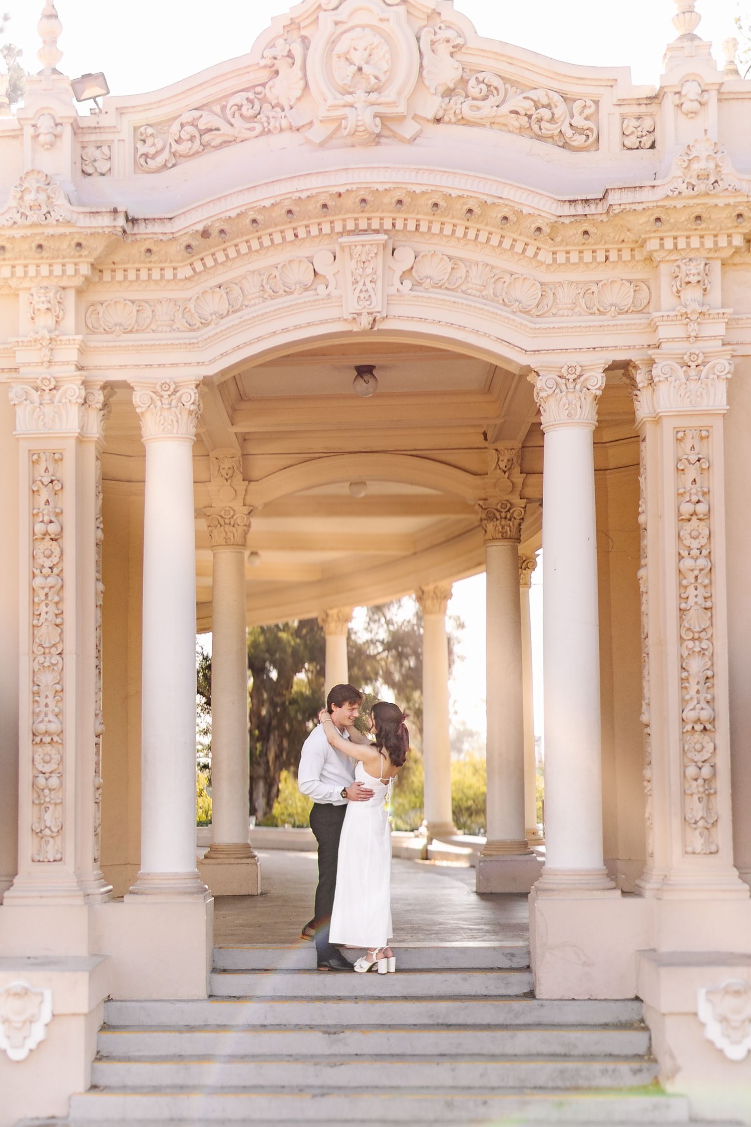 Elegant white colonnade with ornate carved details and classical columns creating a grand entrance.