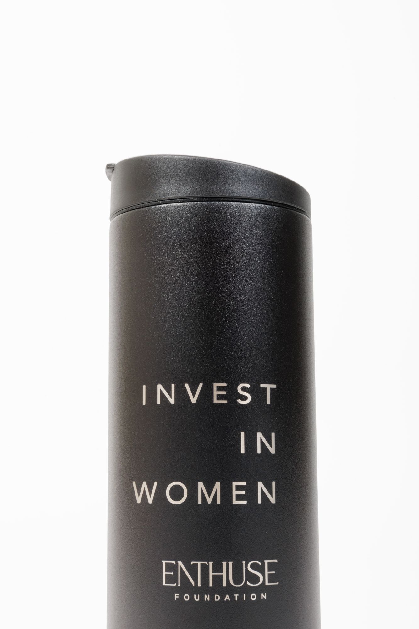 Matte black insulated water bottle with 'INVEST IN WOMEN' and Enthuse Foundation branding.