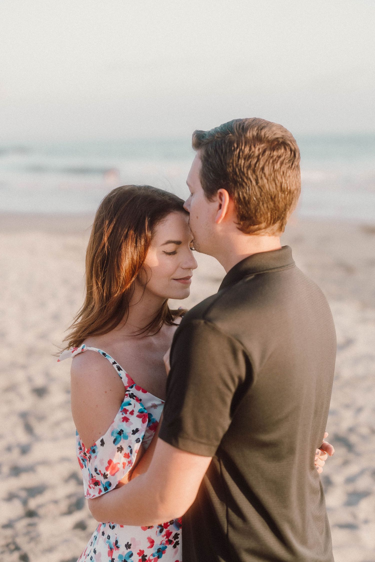 A romantic embrace captured on a serene beach during sunset.