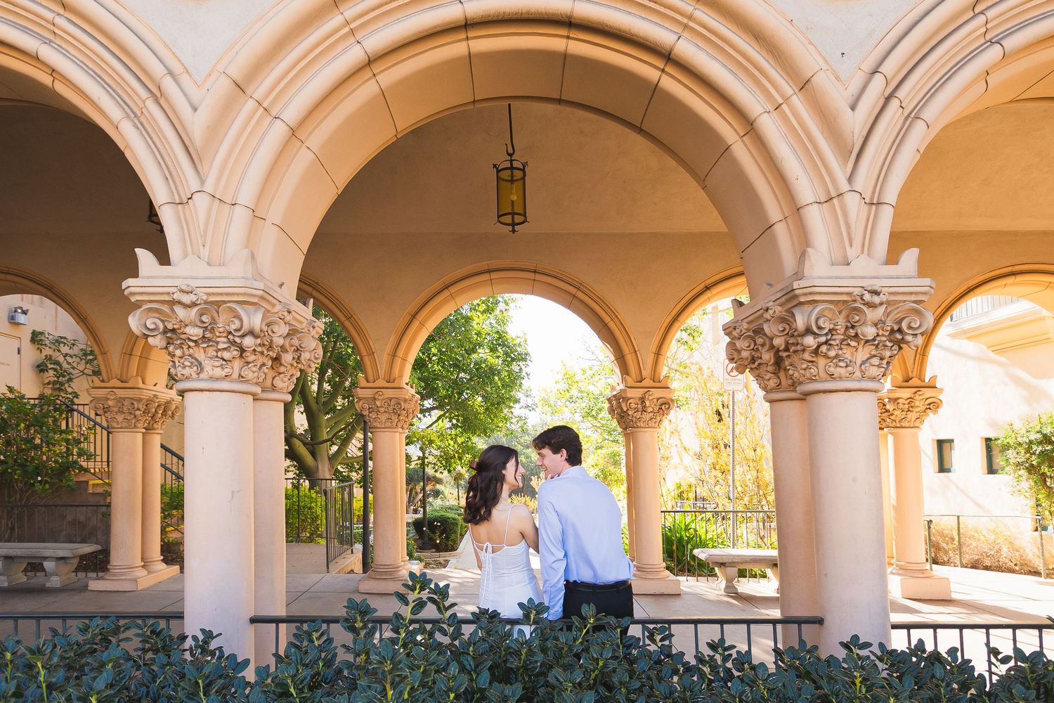 A scenic view of ornate stone arches and columns in a Mediterranean-style courtyard with natural lighting.