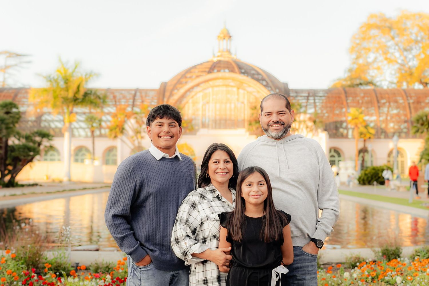 Family portrait session in a scenic park during golden hour with warm autumn lighting.