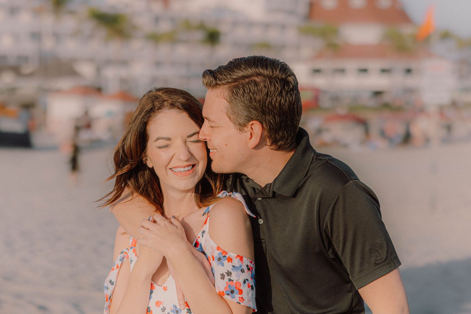Romantic couple sharing tender moments at sunset on the beach in San Diego.