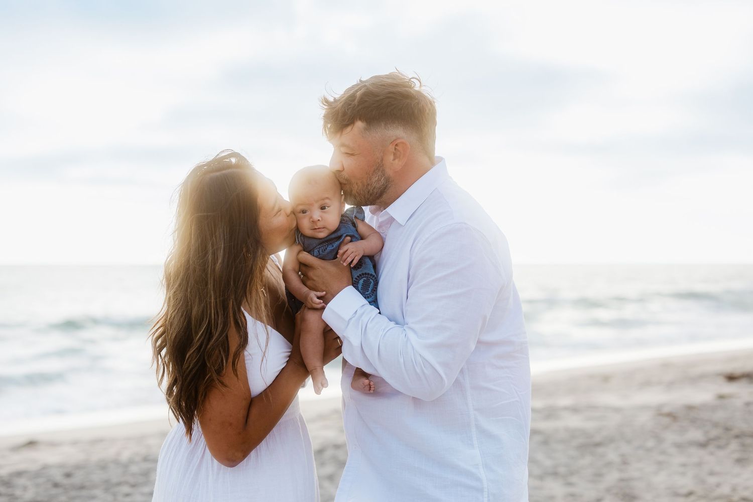 Sweet family moments captured during a beachside photo session at sunset.