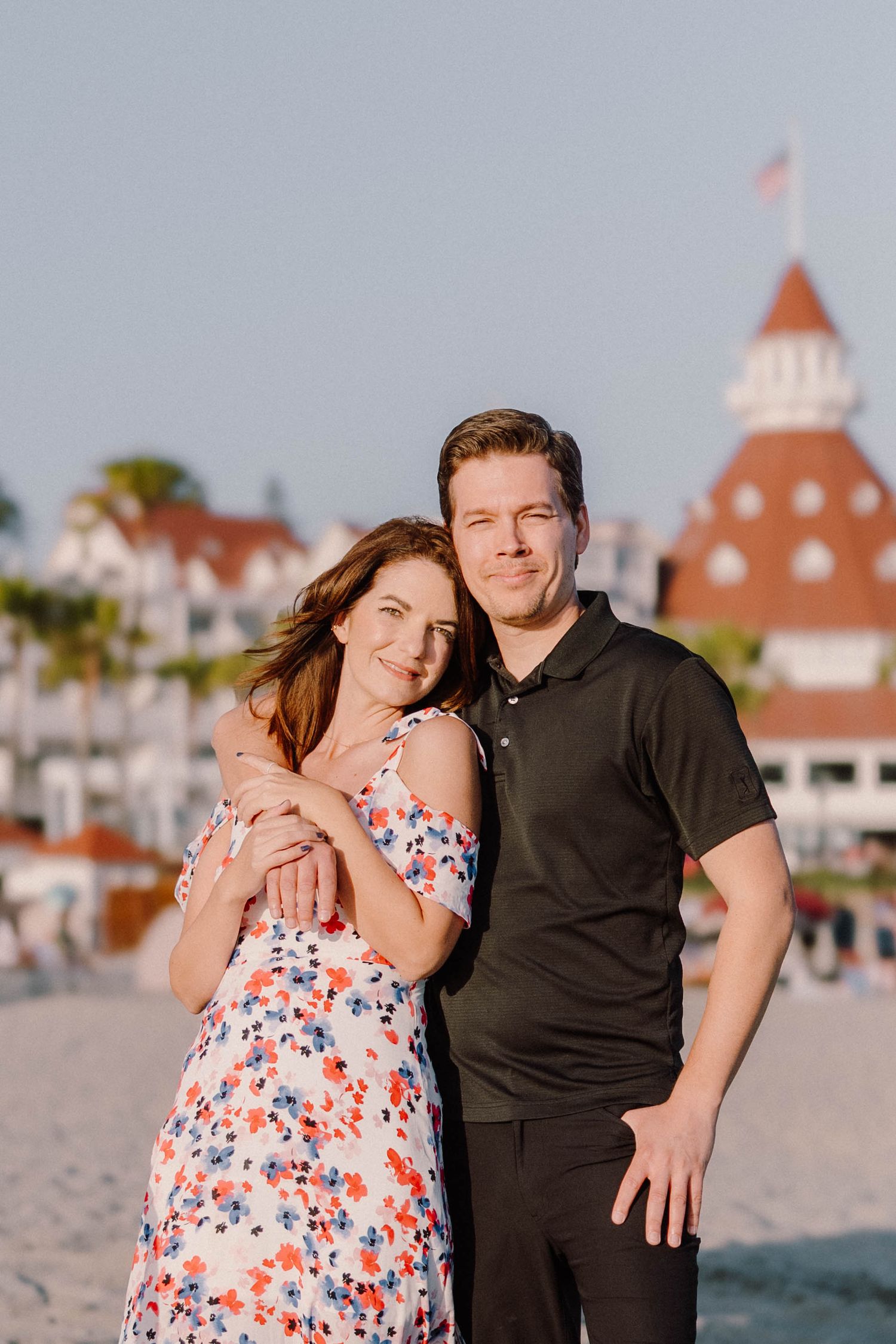 Romantic couple portrait in front of the iconic Hotel del Coronado with its red turret.