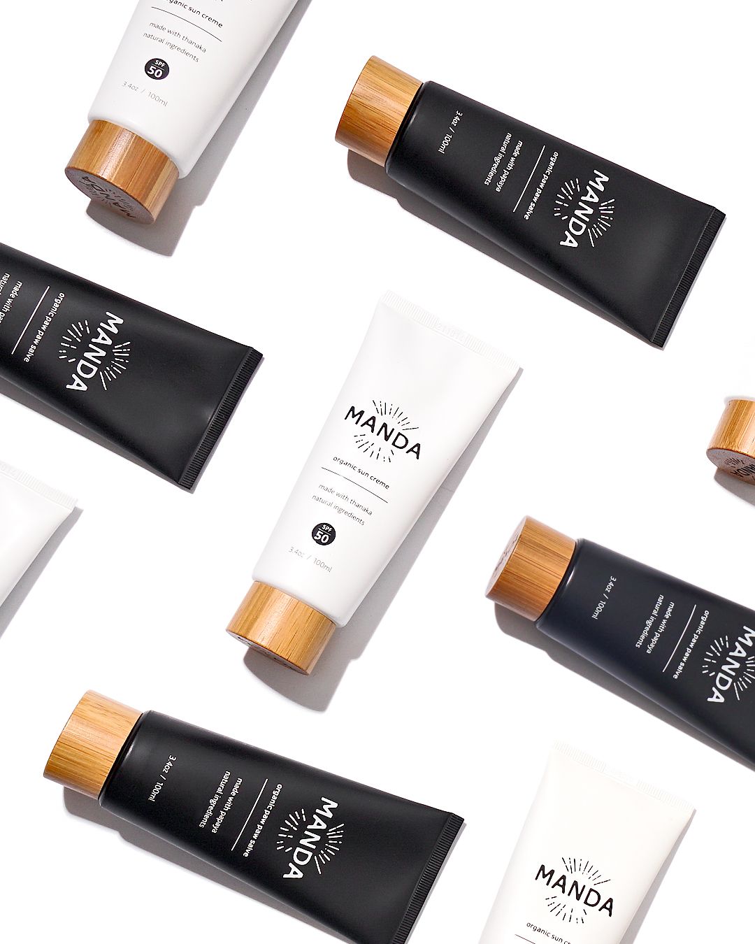 Collection of black and white Manda skincare products arranged in diagonal pattern.