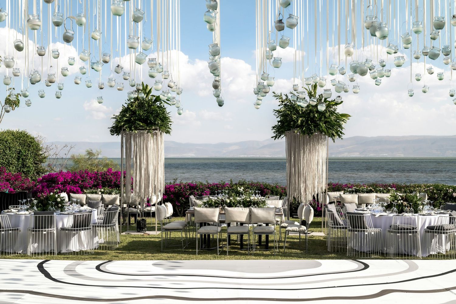 Elegant outdoor wedding venue setup with hanging floral decorations and classical columns.