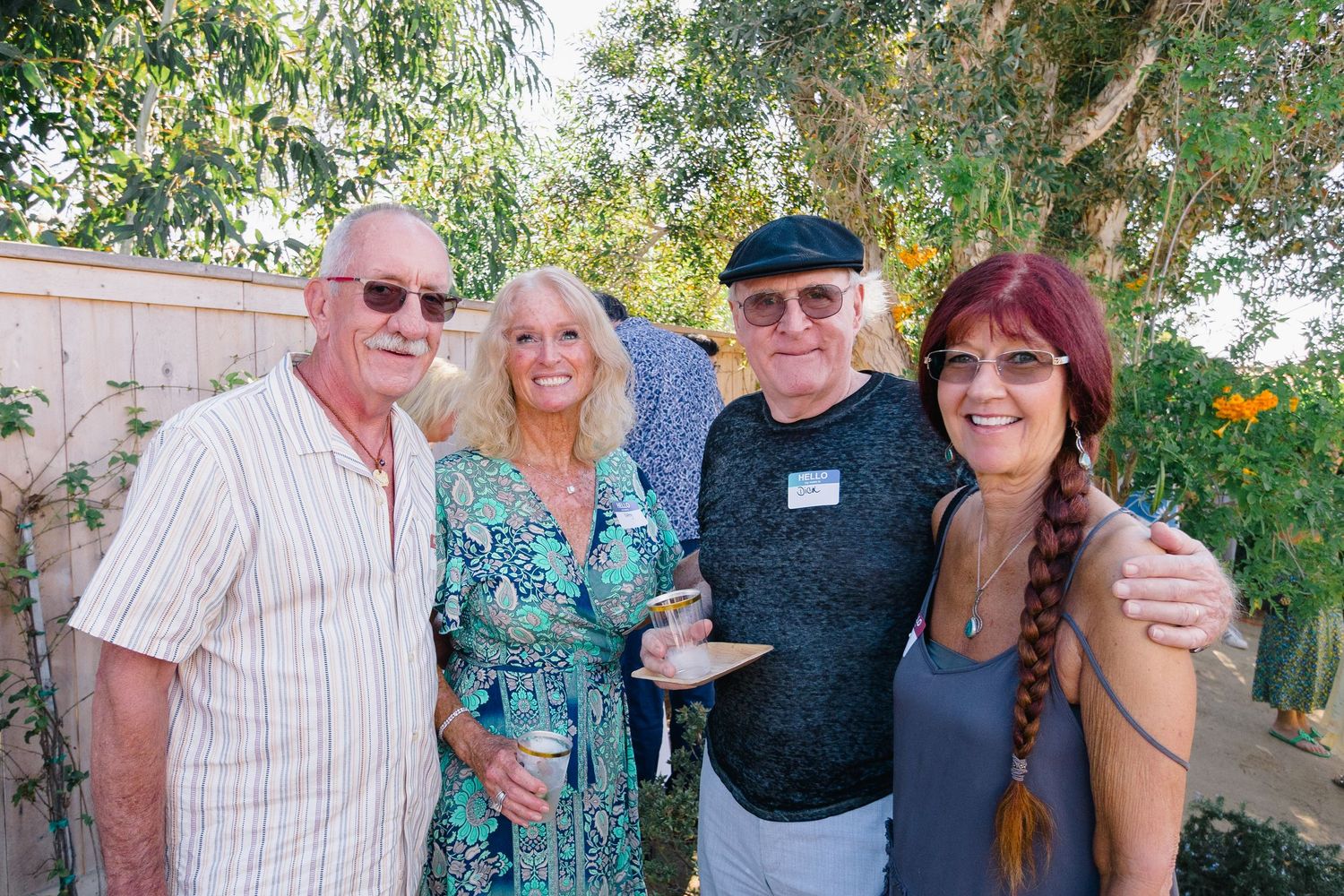 Party guests posing together during a backyard social gathering.