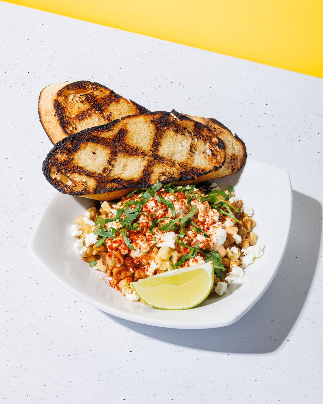 Grilled fish fillet served with cilantro lime rice and garnish on white plates.