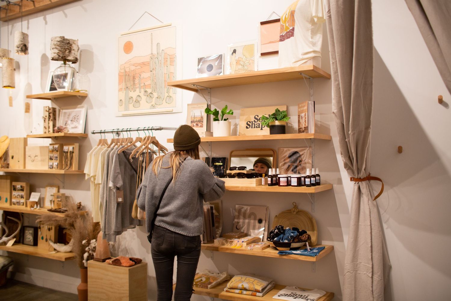 Interior view of a cozy home coffee bar setup with wooden shelving displaying coffee making equipment and supplies.