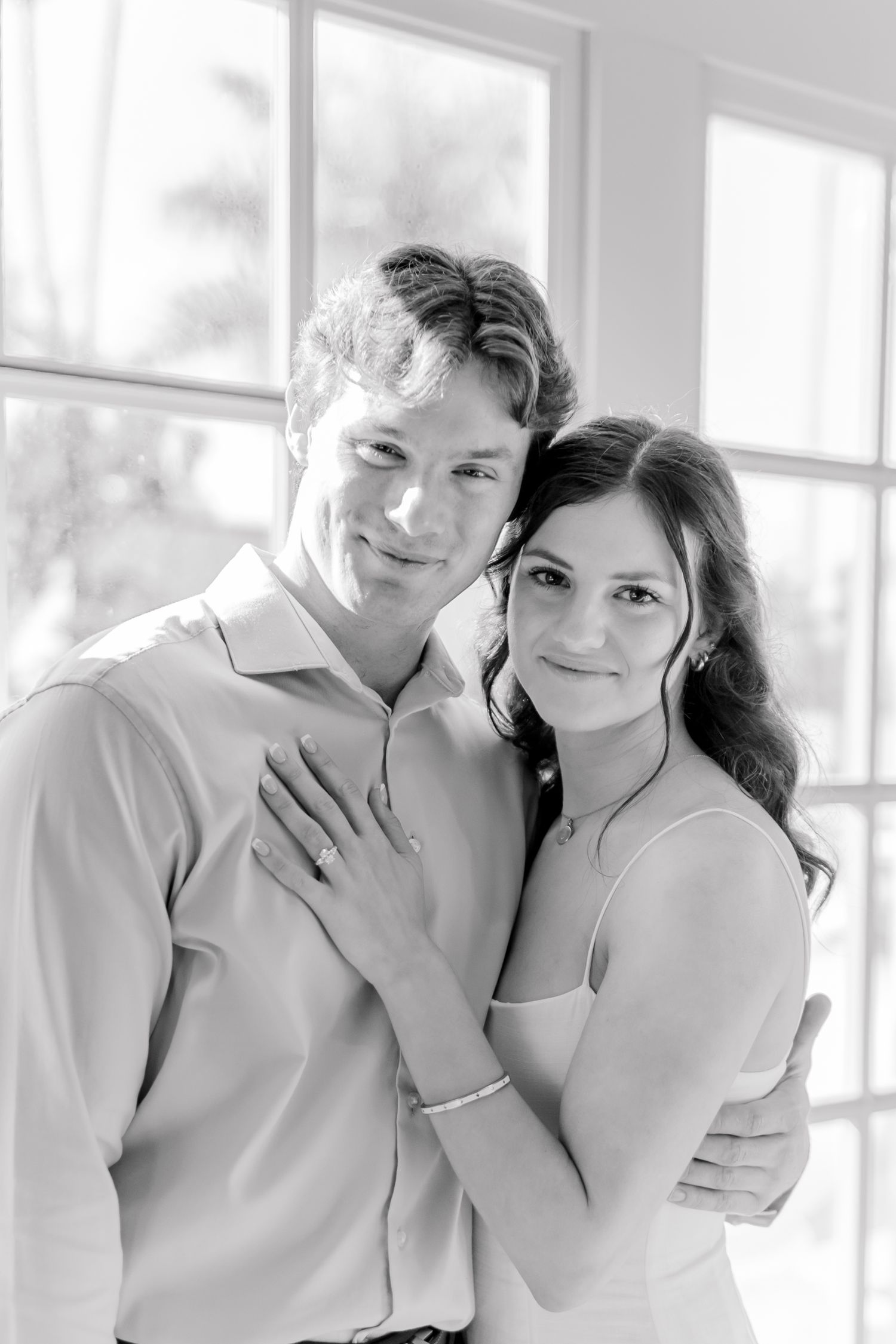 Intimate black and white portrait session in a bright sunlit room with white decor.