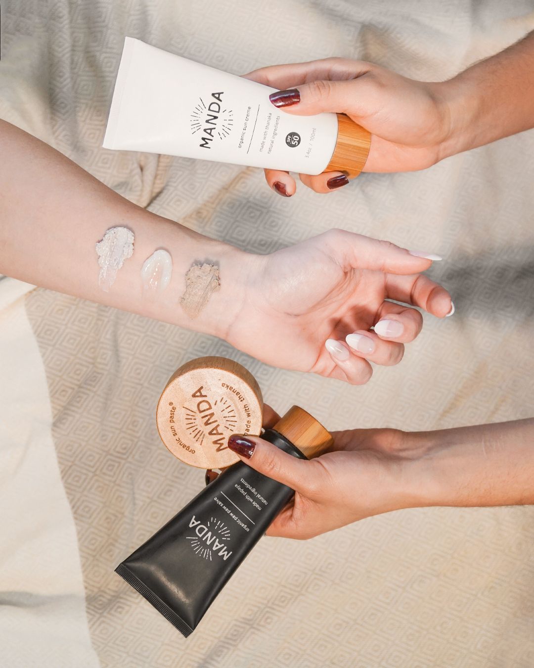 Hands demonstrating application and usage of Manda skincare products on light background.