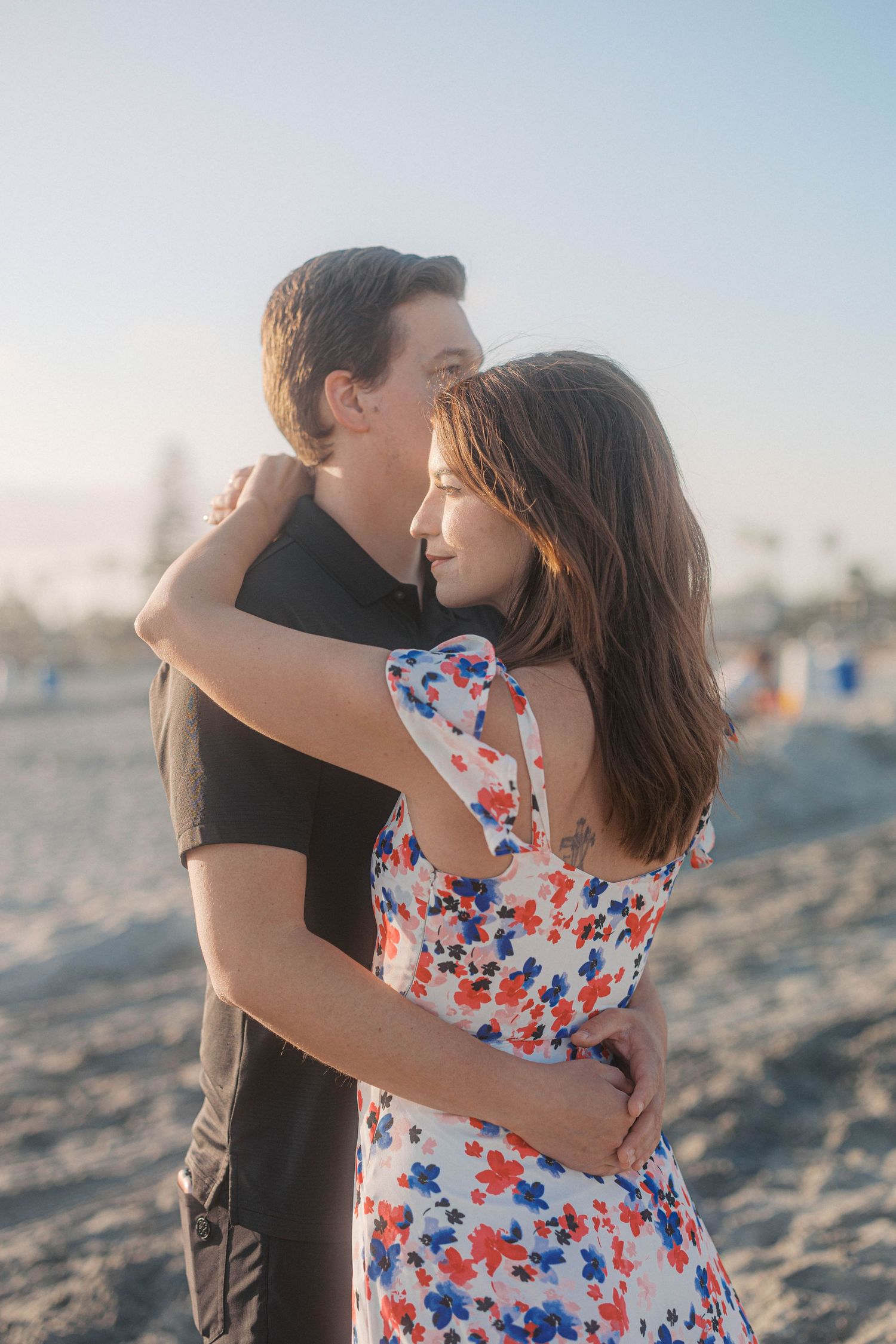 A loving embrace captured during a beach photoshoot at sunset.