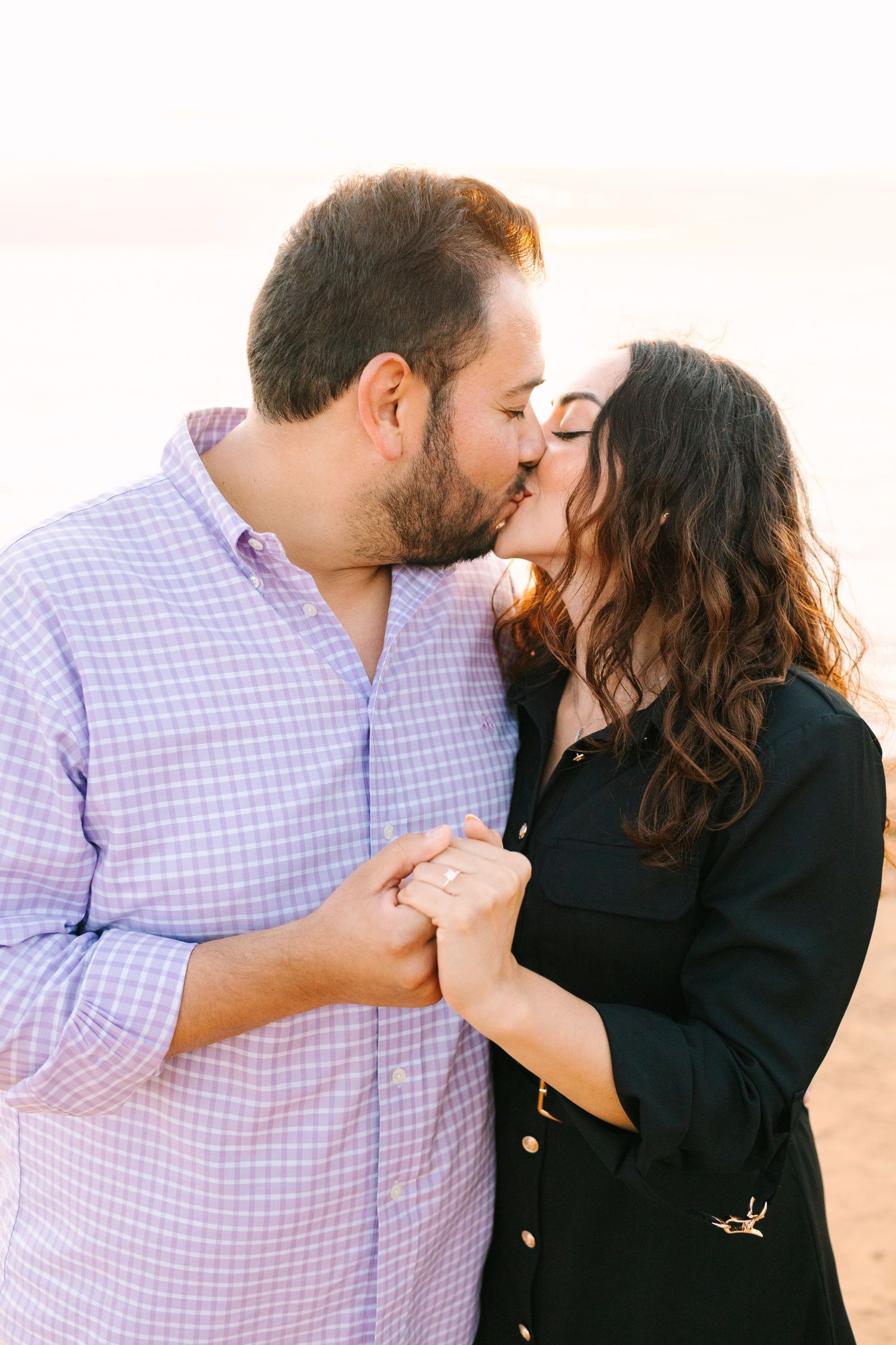 A romantic couple shares tender kisses in a series of intimate photos wearing coordinated purple and black outfits.