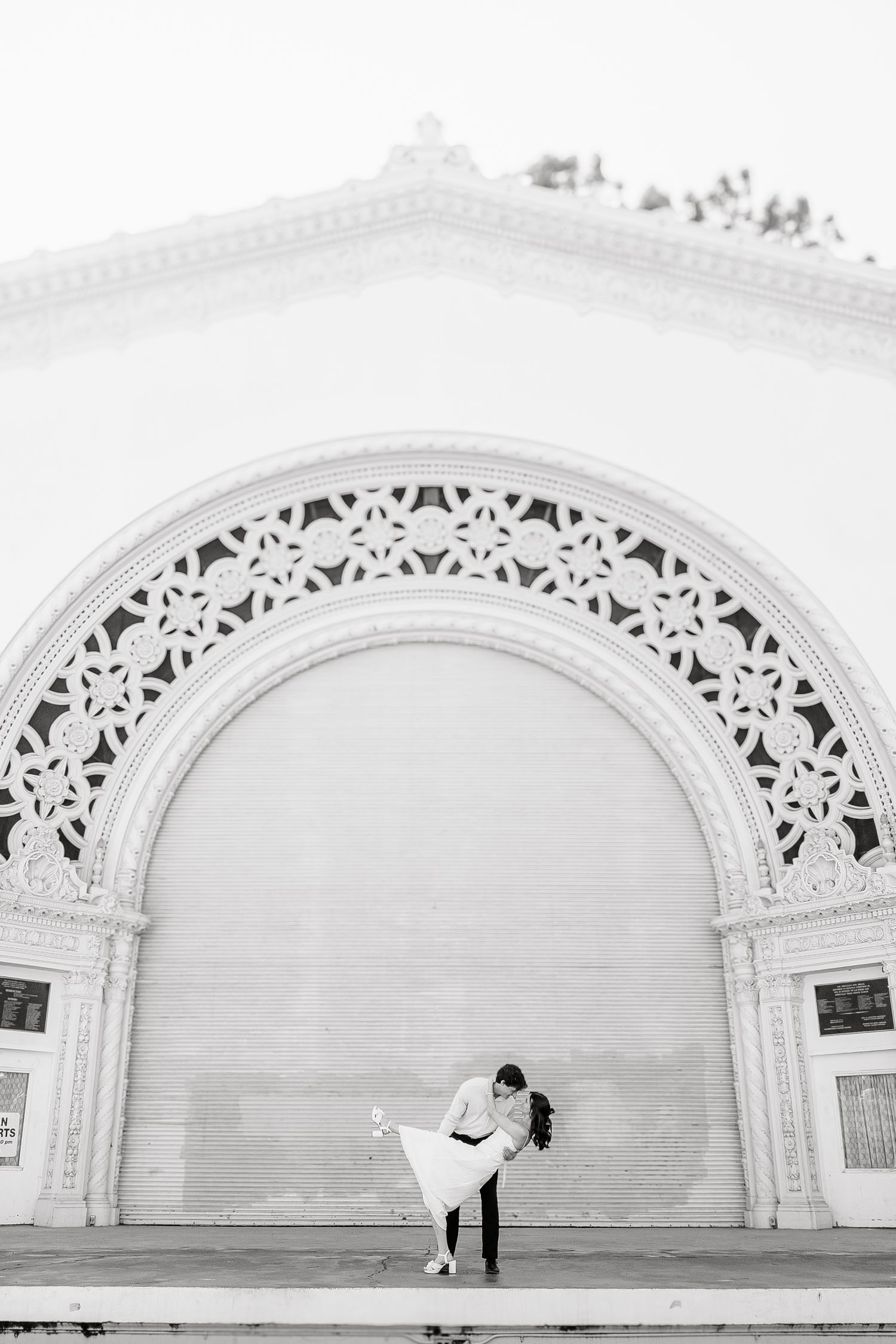 A series of ornate white stone archways with decorative carved details and filigree patterns at the top.