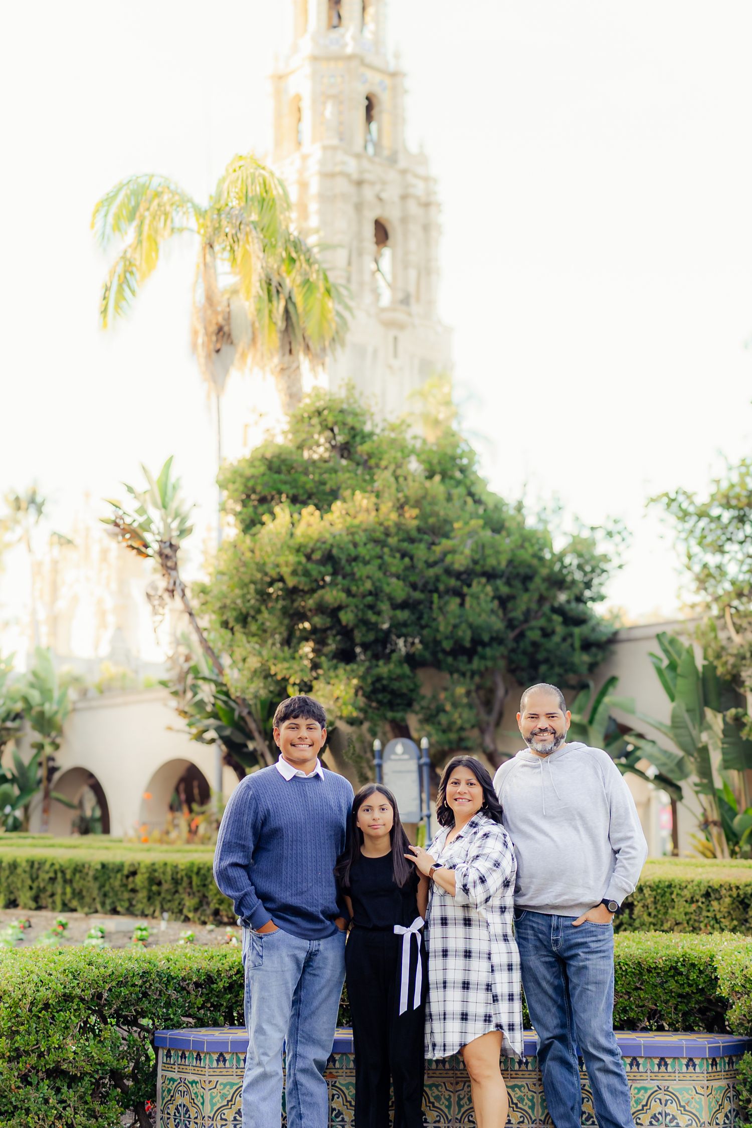 Group photo taken in front of a Spanish colonial style building with palm trees and ornate architecture.