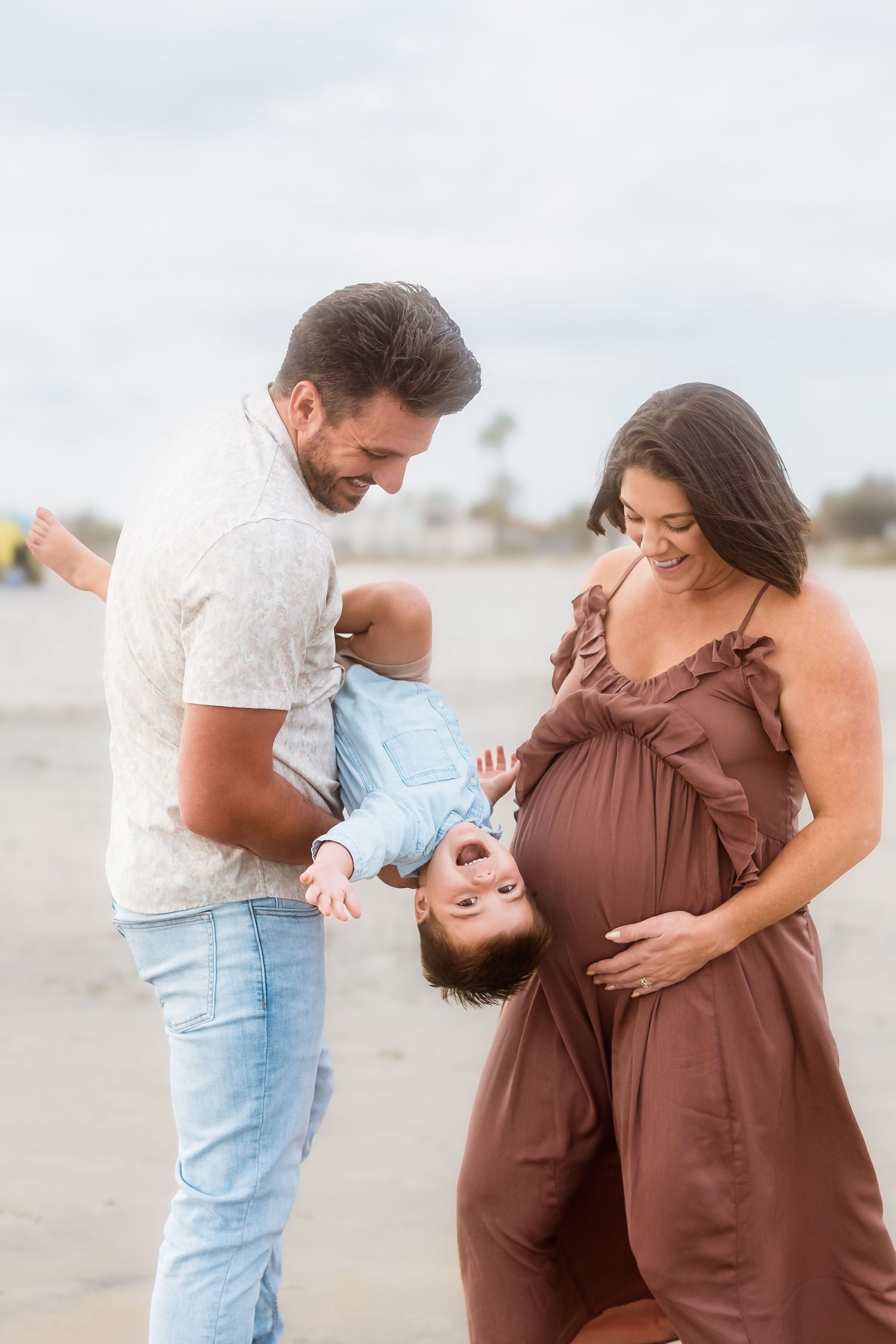 Couple shares tender moments together on a beach during sunset photoshoot.