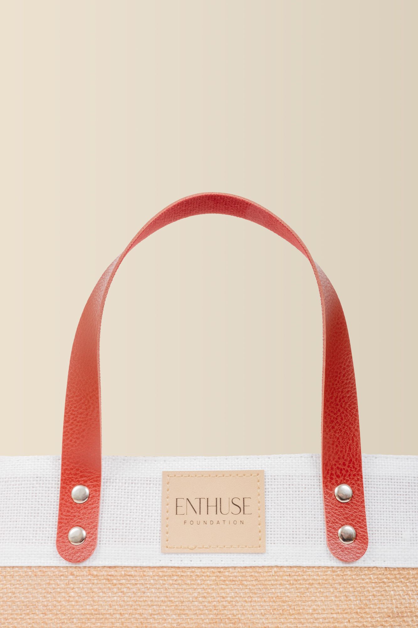 White canvas tote bag with red leather handles and Centurise branding detail.