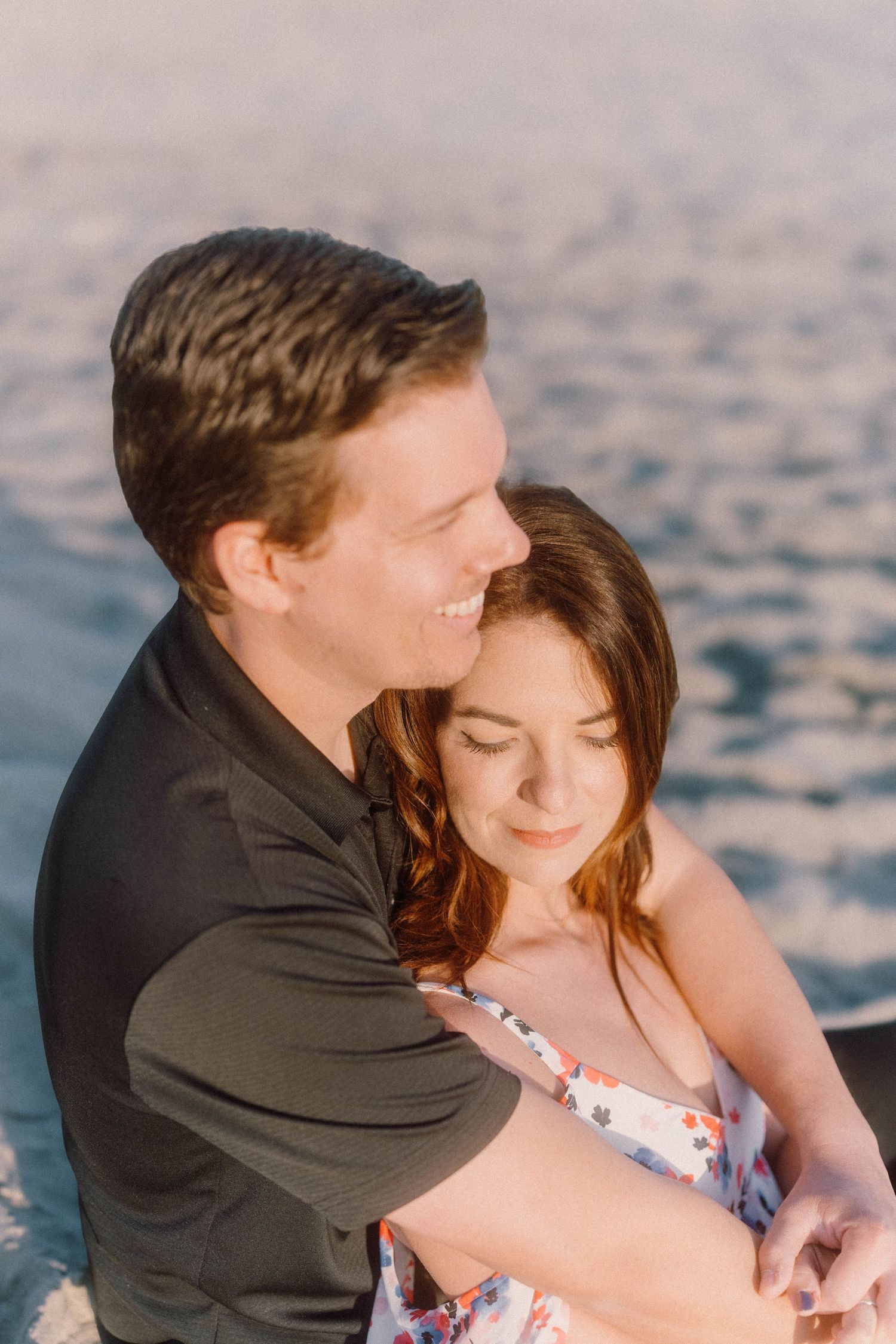 Intimate beachside portrait of couple embracing during golden hour.