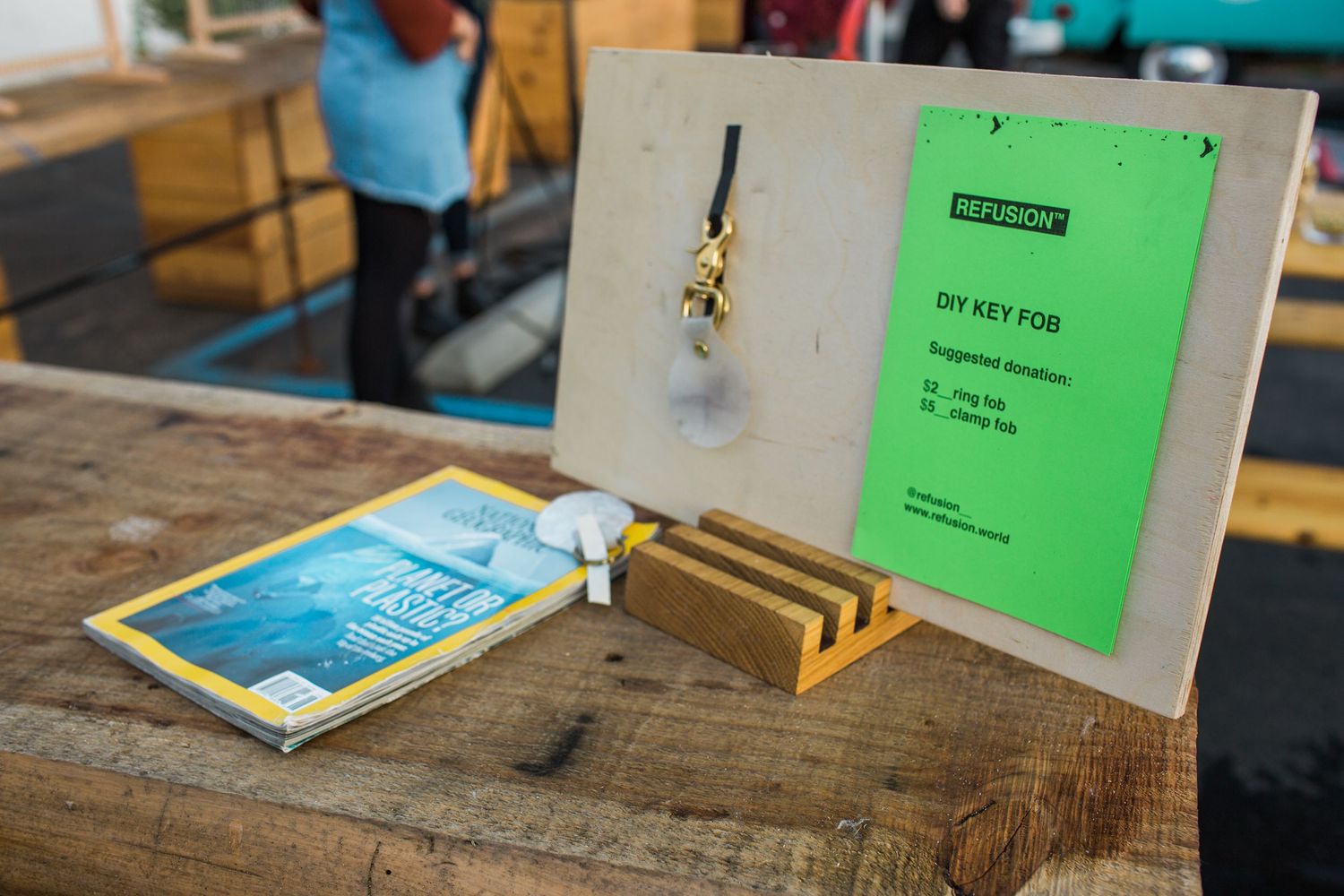 Sequence of screen printing equipment and supplies laid out on a wooden workbench with turquoise and green elements.