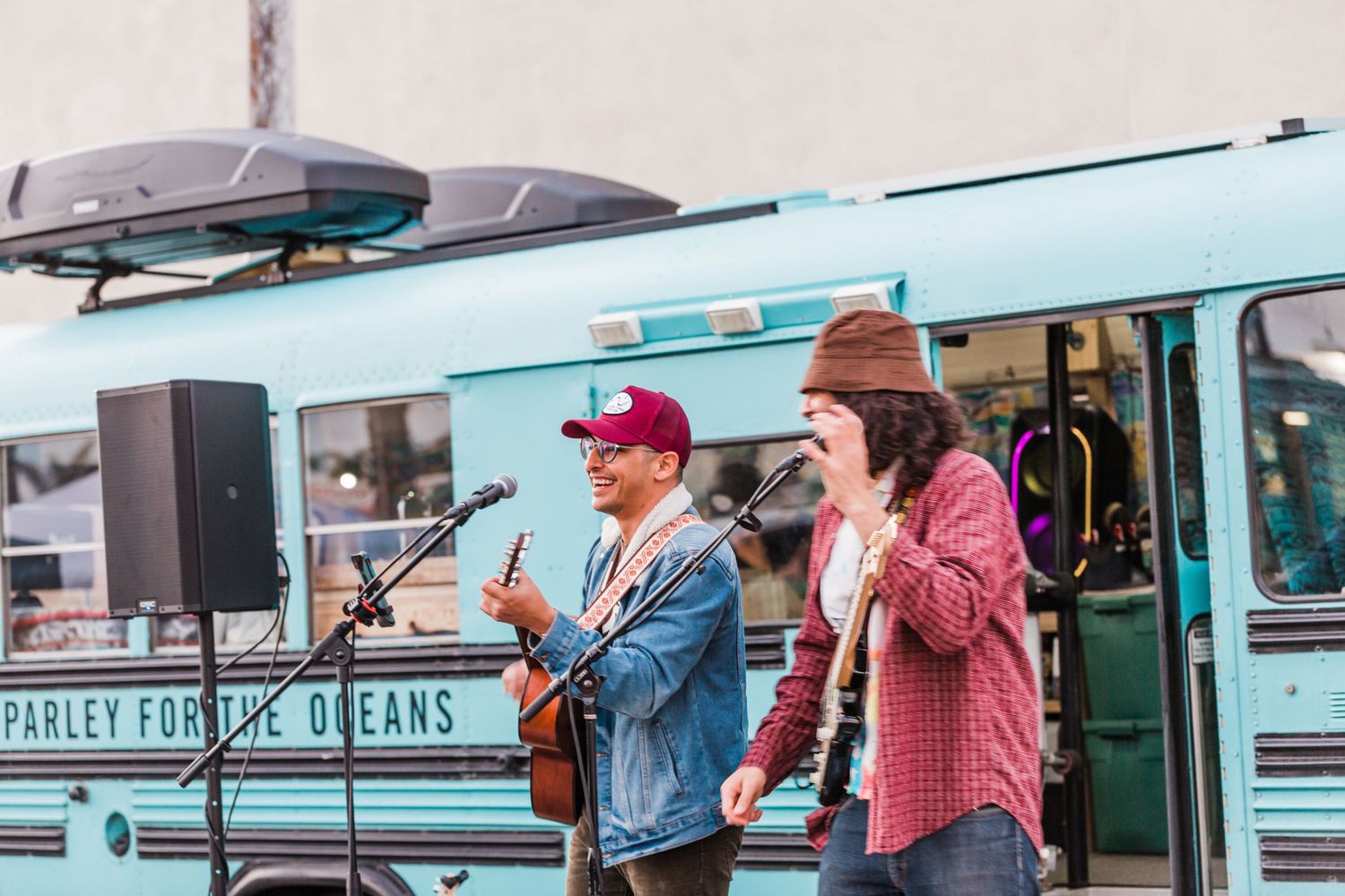 Vintage turquoise bus transformed into a food truck parked alongside other retro-styled mobile dining vehicles.