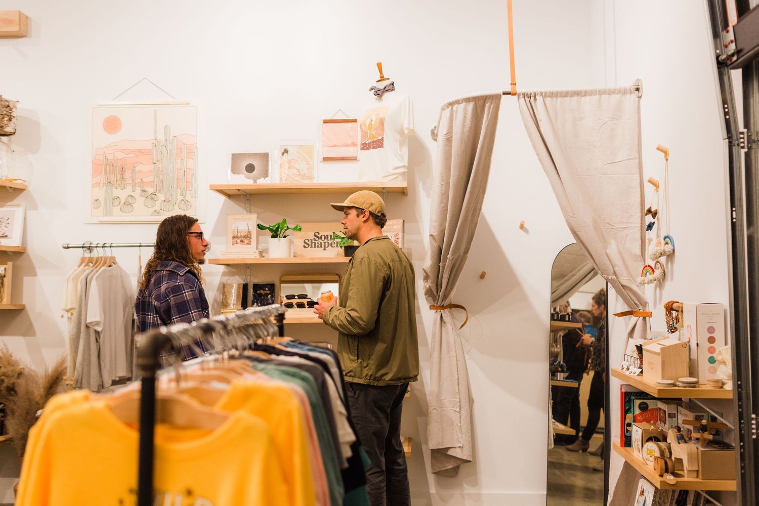 A showroom display features a layout of furniture and lighting with multiple hanging pendant lamps and home decor items.