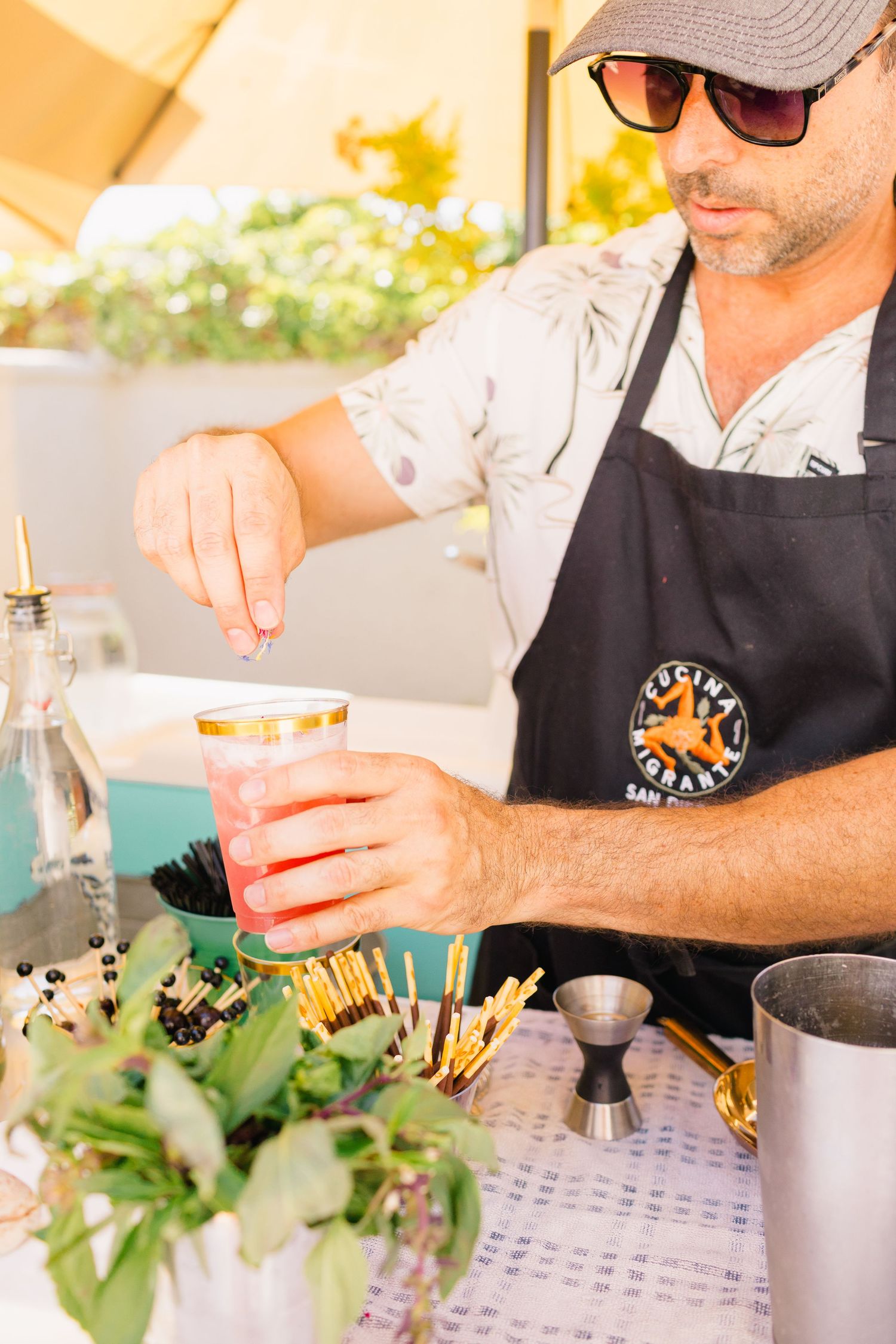 Bartenders preparing cocktails at an outdoor event bar station.