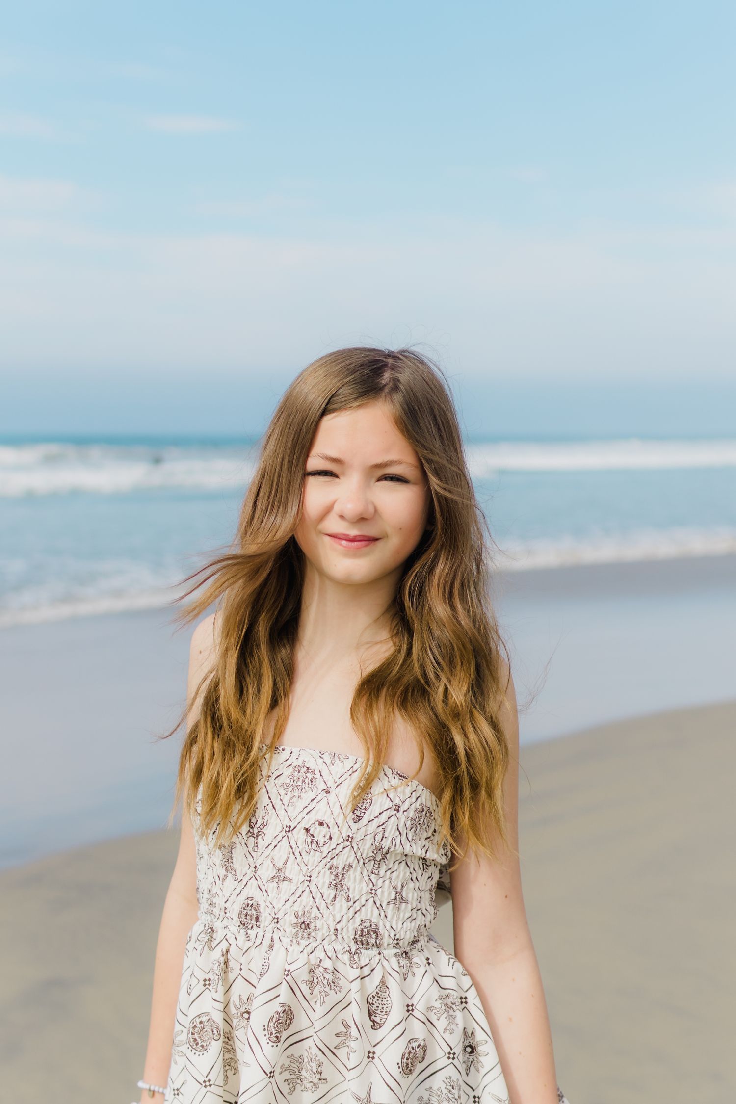 A series of portraits taken at a sunny beach with waves and sand in the background.
