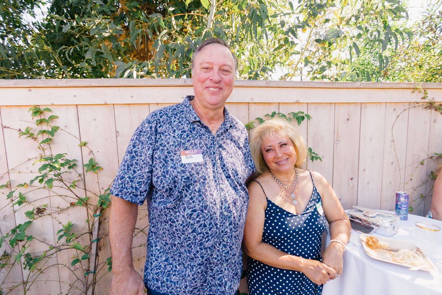 People socializing at an outdoor garden party on a bright summer day.