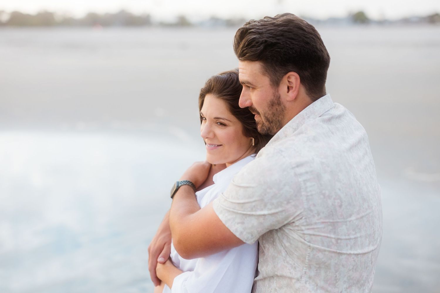 Soft, romantic beach portraits capturing tender moments between an expecting couple.