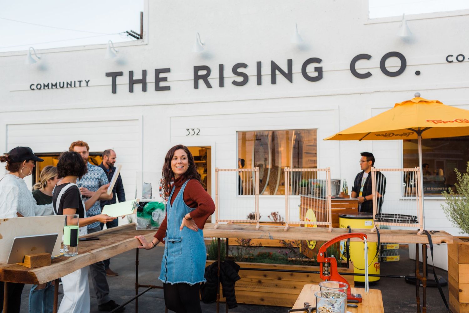 Workers and furniture are visible through the windows of The Rising Co, a bright community retail space.