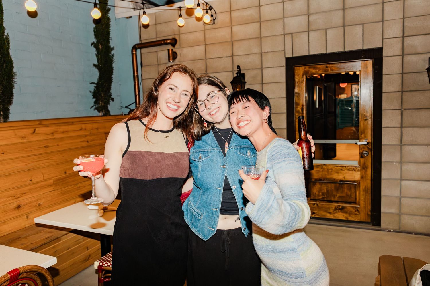 Friends enjoying drinks together at cozy indoor restaurant venue.