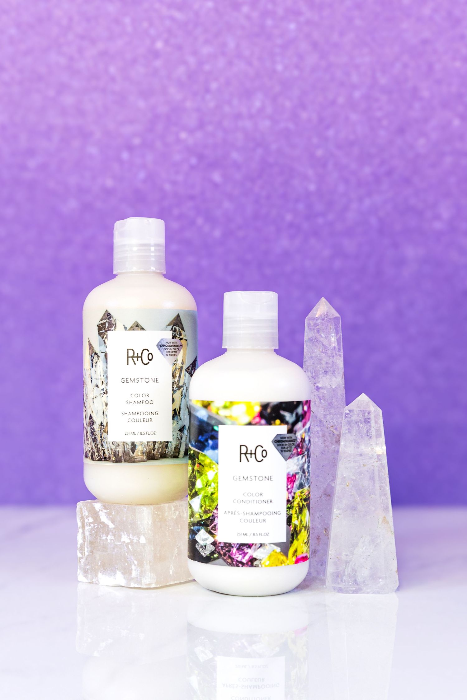 R+Co hair products displayed with crystal quartz points against a purple sparkly background.