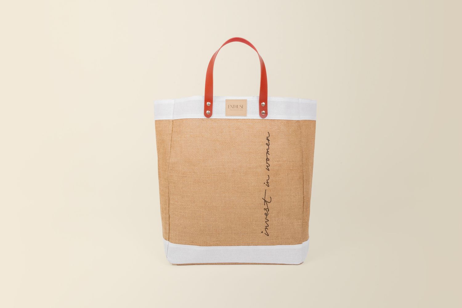 Side view of a two-tone canvas tote bag with red handles against neutral background.