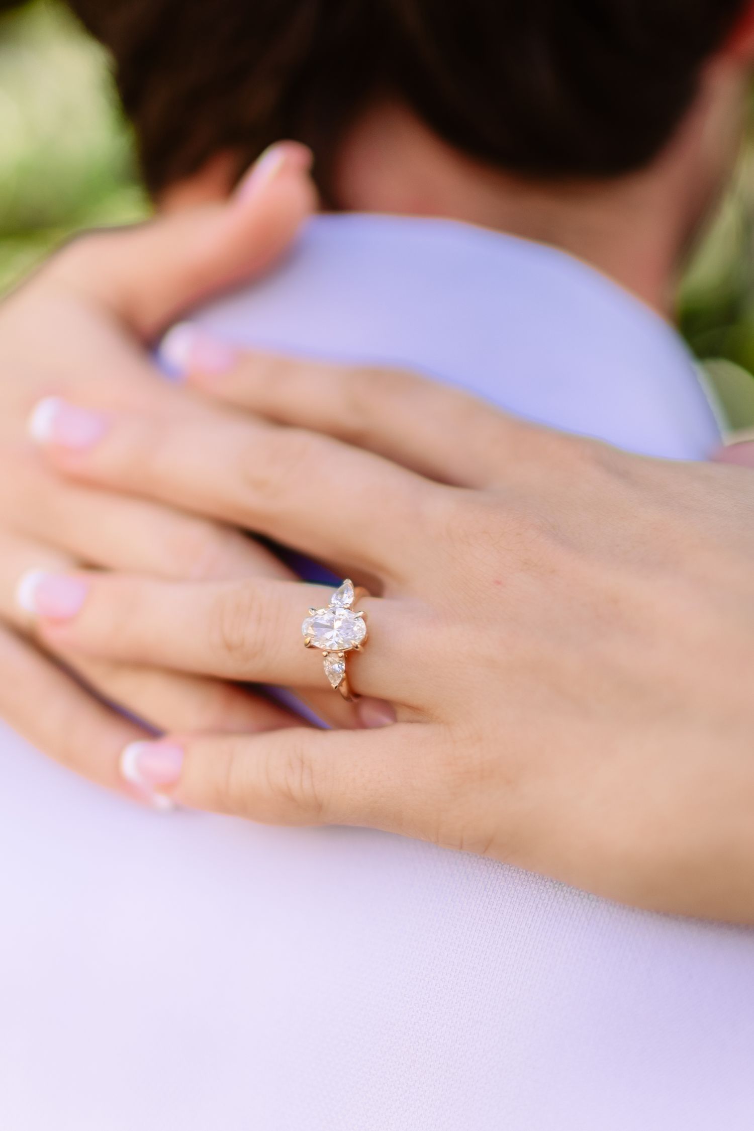 Close-up of a hand wearing an elegant diamond engagement ring with a sparkling solitaire stone.