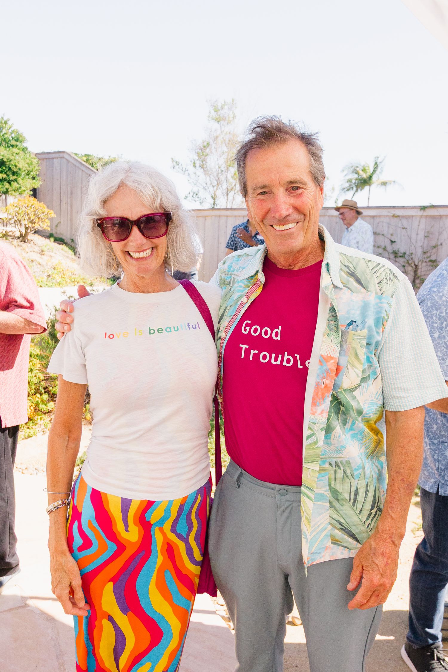 Group photo of attendees wearing colorful summer outfits at an outdoor gathering.