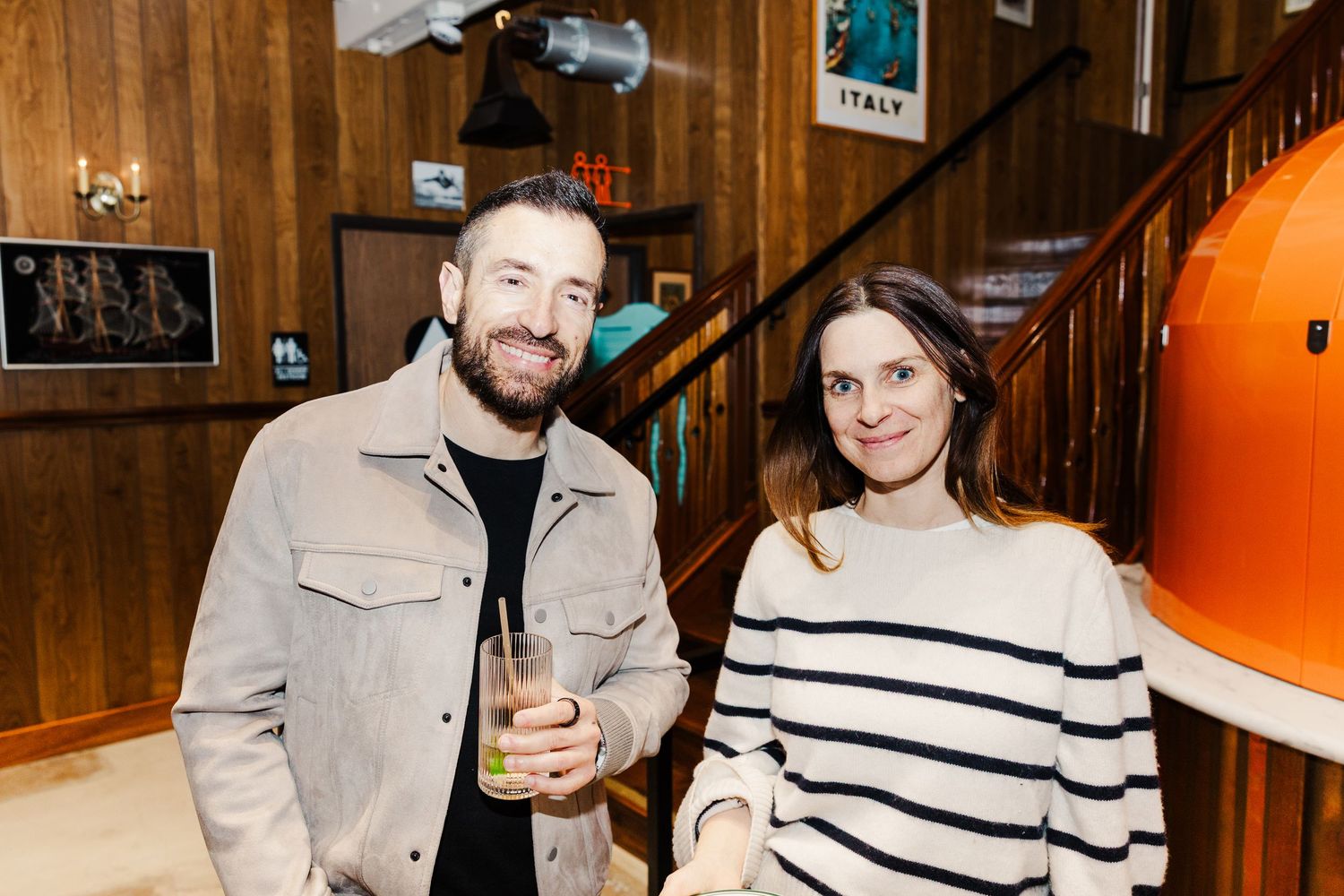 A lively celebration in a rustic wooden venue with string lights overhead during what appears to be an engagement party.