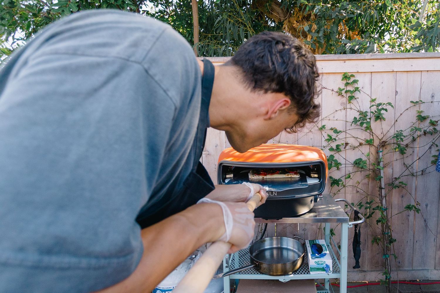 Person preparing food at an outdoor cooking station with professional equipment.