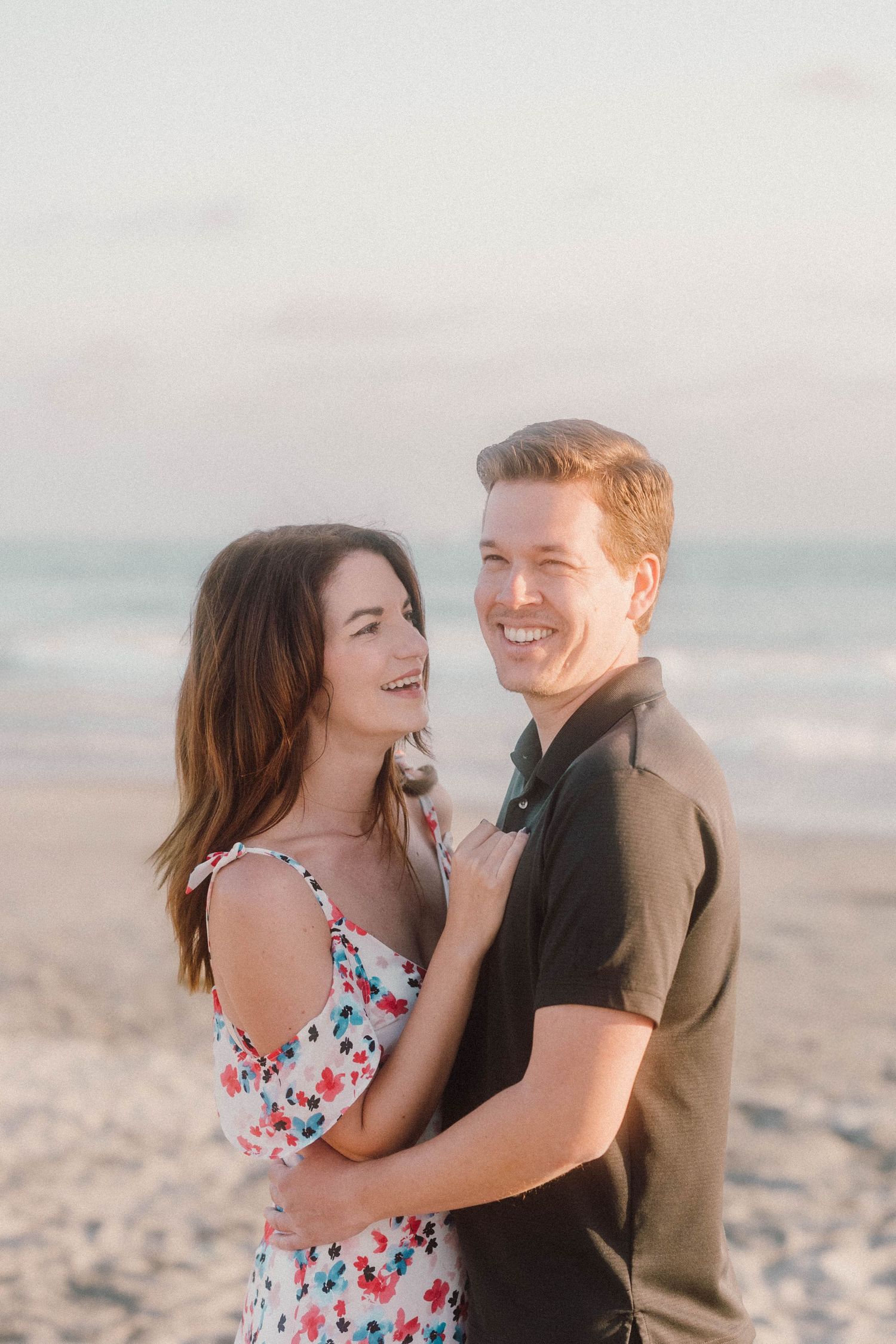A joyful moment shared between a couple during their beach photoshoot.