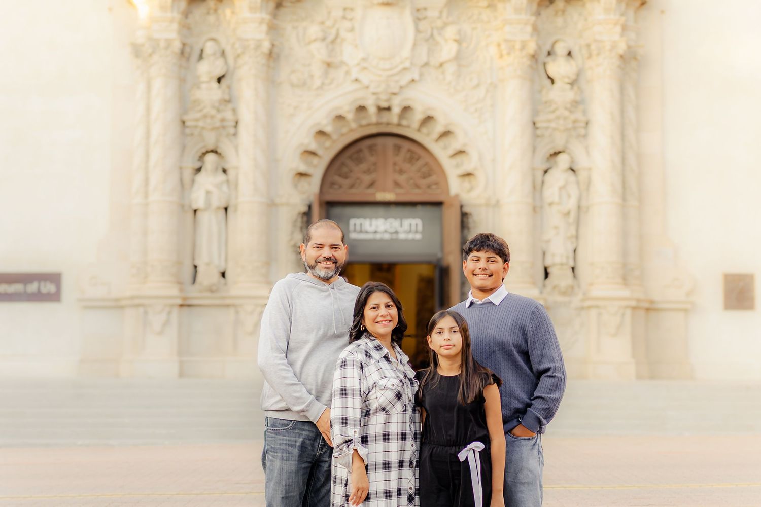 Family members gather for photos in front of a historic mission-style building with Spanish colonial architecture.
